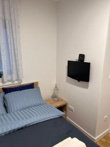 a bedroom with a bed and a flat screen tv on the wall at Apartman 8 Panorama sa garažom in Bjelašnica +10 photos