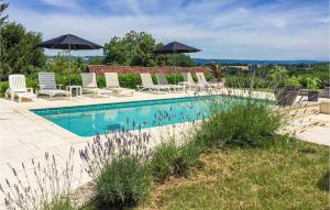 a swimming pool with lounge chairs and umbrellas at Amazing Home In Monfaucon With Wifi, Outdoor Swimming Pool And Swimming Pool in Monfaucon