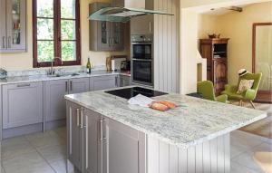 a kitchen with a granite counter top and a kitchen island at Amazing Home In Monfaucon With Wifi, Outdoor Swimming Pool And Swimming Pool in Monfaucon