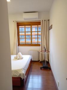 Habitación pequeña con cama y ventana en Aconchegante Apartamento no Centro de Gramado, en Gramado