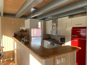 cocina con encimera de madera y nevera roja en Ferienhaus mit Wasserterrasse - mit Sauna und Kamin - inklusive Nebenkosten, en Wendisch Rietz