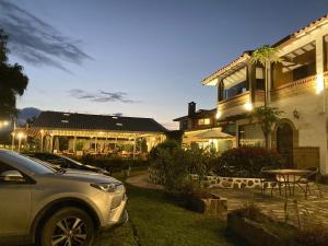 un coche aparcado delante de una casa por la noche en Bombon Hotel, en Villa de Leyva