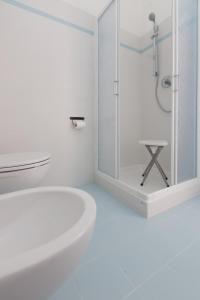 a white bathroom with a shower and a white tub at Affittacamere Le Giare in Riomaggiore