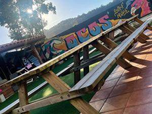 a wooden bench with graffiti on the side of it at COCOS SURFHOUSE in San Juan de la Arena