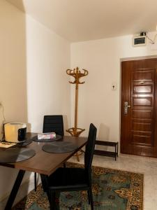 a dining room with a table and a wooden door at Cozy Apartment in Braşov