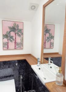 een badkamer met een wastafel en een spiegel bij Seapink, Kingsand; luxury Cornish cottage with seaviews, bbq & paddleboards in Kingsand