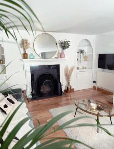 een woonkamer met een open haard en een tafel bij Seapink, Kingsand; luxury Cornish cottage with seaviews, bbq & paddleboards in Kingsand