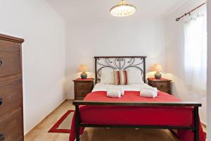 カバナス・デ・タビラにあるCabanas Villageのベッドルーム1室(赤いベッド1台、ナイトスタンド2台付)