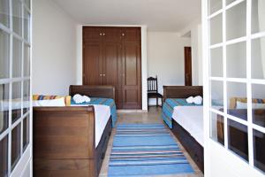 Habitación pequeña con 2 camas y pasillo en Cabanas Village, en Cabanas de Tavira