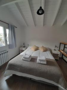 1 dormitorio blanco con 1 cama grande y 2 almohadas en VERA Apart en El Chaltén