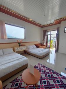 uma sala de estar com 2 camas, uma mesa e um sofá em Villa madinna dieng em Diyeng