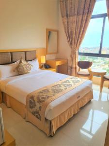 a bedroom with a large bed and a large window at Hotel Express in Luanda