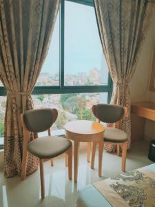 Habitación con 2 sillas, mesa y ventana en Hotel Express en Luanda