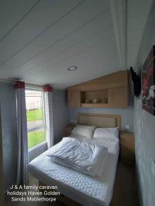 Säng eller sängar i ett rum på J&A Family Caravan Haven Mablethorpe