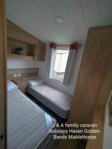 a small room with a bed and a window at J&A Family Caravan Haven Mablethorpe in Mablethorpe