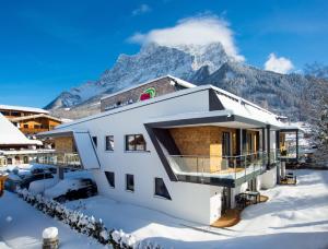 a house in the snow with a mountain in the background at Apartment S in Ehrwald