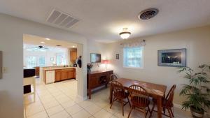 a kitchen and dining room with a table and chairs at AZALEA COTTAGE DUPLEX Duplex in Jekyll Island