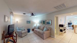 a living room with a couch and a tv at AZALEA COTTAGE DUPLEX Duplex in Jekyll Island