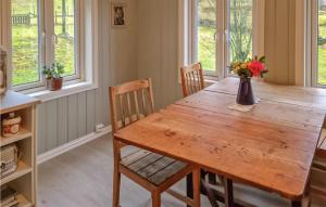 Eide的住宿－Amazing Home In Hidrasund With Wifi，一间带木桌和椅子的用餐室
