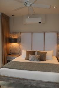 a bedroom with a large bed with a ceiling fan at Matisia Hotel Boutique in Guaduas