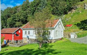 Eide的住宿－Amazing Home In Hidrasund With Wifi，山丘上一座有两座红色建筑的房子