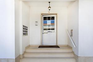 a hallway with a white door and stairs at Cabanas Vintage Apartment in Tavira