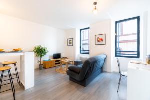 una sala de estar con un sofá y una mesa en Le Combarel, en Rodez
