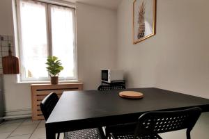 a dining room with a black table and chairs at Logement entier proche tribunaux in Douai +6 photos