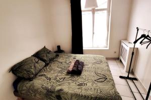 a bedroom with a bed with a pair of shoes on it at Logement entier proche tribunaux in Douai