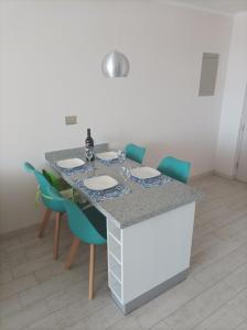 eine Küche mit einem Tisch mit Stühlen und einer Arbeitsplatte in der Unterkunft Vista Pacifico, Serena in La Serena