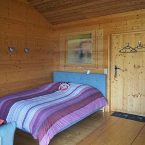 ein Schlafzimmer mit einem Bett in einer Holzhütte in der Unterkunft Studio Raccard Cendré in Grône