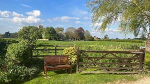 a wooden bench sitting in front of a fence at Church View in Weston Subedge
