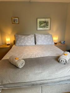 a bedroom with a bed with two towels on it at Church View in Weston Subedge