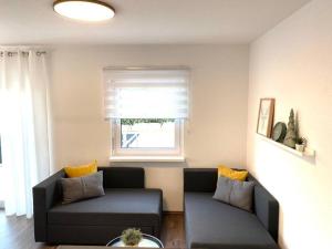 a living room with two couches and a window at Ferienwohnung, Fischerbach im Kinzigtal in Fischerbach