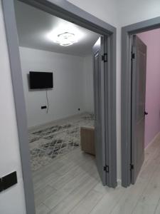 a room with a door open to a room with a television at Sezim Qala 10 in Taldykolʼ