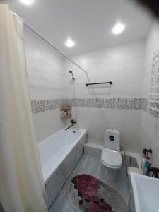 a bathroom with a white tub and a toilet at Sezim Qala 10 in Taldykolʼ