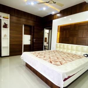 a bedroom with a large bed and wooden walls at Sunspot -Entire Villa Apartment in Ujjain