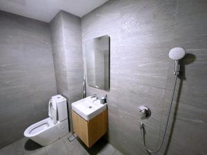 La salle de bains est pourvue d'un lavabo, de toilettes et d'un miroir. dans l'établissement REVO Pavilion SkyPool LS09, à Kuala Lumpur