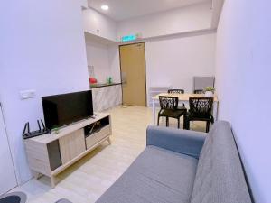 - un salon avec un canapé, une télévision et une table dans l'établissement REVO Pavilion SkyPool LS09, à Kuala Lumpur