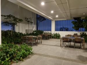 - une salle à manger avec des tables, des chaises et des fenêtres dans l'établissement REVO Pavilion SkyPool LS09, à Kuala Lumpur