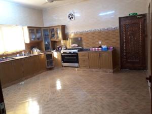 uma grande cozinha com armários de madeira e um forno em The calm place in Nizwa em Al Jināh