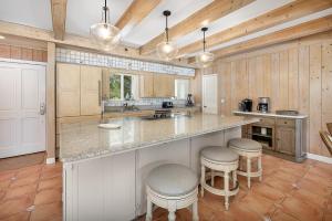 a kitchen with a large island with bar stools at JEKYLL HOUSE home in Jekyll Island