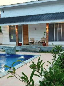 a house with a swimming pool in front of a house at Villa Sawah Prambanan in Randugunting