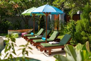 una fila de sillones con sombrilla en Rose Valley Villa, en Amed