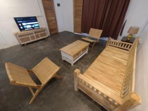 a living room with wooden furniture and a television at Villa Sawah Prambanan in Randugunting