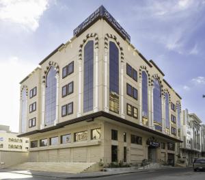 a large building with blue windows on a street at Qasr Al Sahab Hotel Makkah in Makkah