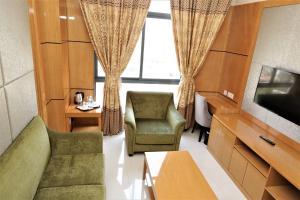 Hotel Express في لواندا: غرفة معيشة مع أريكة وكراسي وتلفزيون