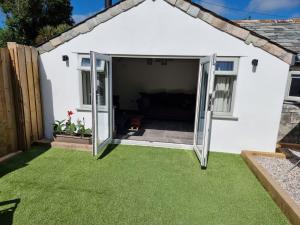 a garden room with sliding glass doors at The Old Pottery 2 Person Dog Friendly Cottage in Delabole