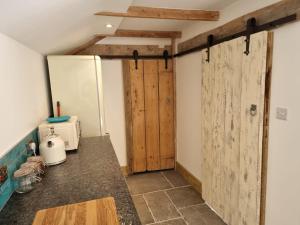 cocina con puerta de madera y encimera en The Old Pottery 2 Person Dog Friendly Cottage, en Delabole