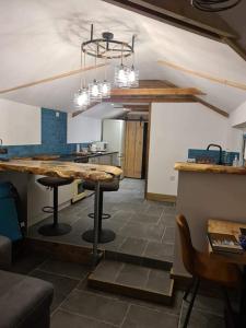 a kitchen with a table and stools in a room at The Old Pottery 2 Person Dog Friendly Cottage in Delabole